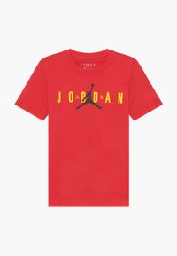 Červené bavlněné tričko s žlutou a černou grafikou "JORDAN" a siluetou skákající postavy. Klasický střih s kulatým výstřihem.