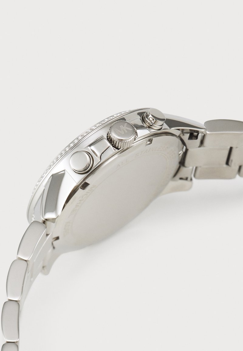 Montre en acier inoxydable argenté avec une lunette lisse, deux poussoirs, une couronne pour les réglages et un bracelet à maillons.