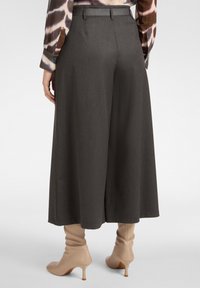 Brede charcoal broek van een gladde, gestructureerde stof, met een getailleerd ontwerp, hoge taille en subtiele riemaccenten.