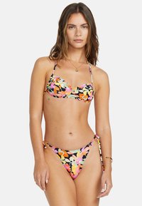 Blommig bikini med flerfärgade blommor på en svart bas, med ett veckat bandeau-top och knytbara bottoms. Mjuk textur.