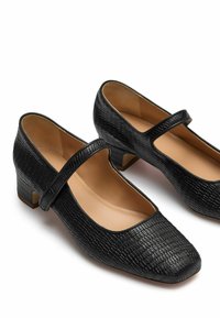 Scarpe Mary Jane in pelle nera testurizzata con punta quadrata, tacco basso e una sottile fascia a livello del piede. Fodera interna liscia.