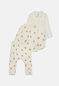 Set med tre babykläder i mjuk krämfärgad tyg: en enfärgad bodysuit, en mönstrad topp med djurtryck och matchande tryckta byxor.
