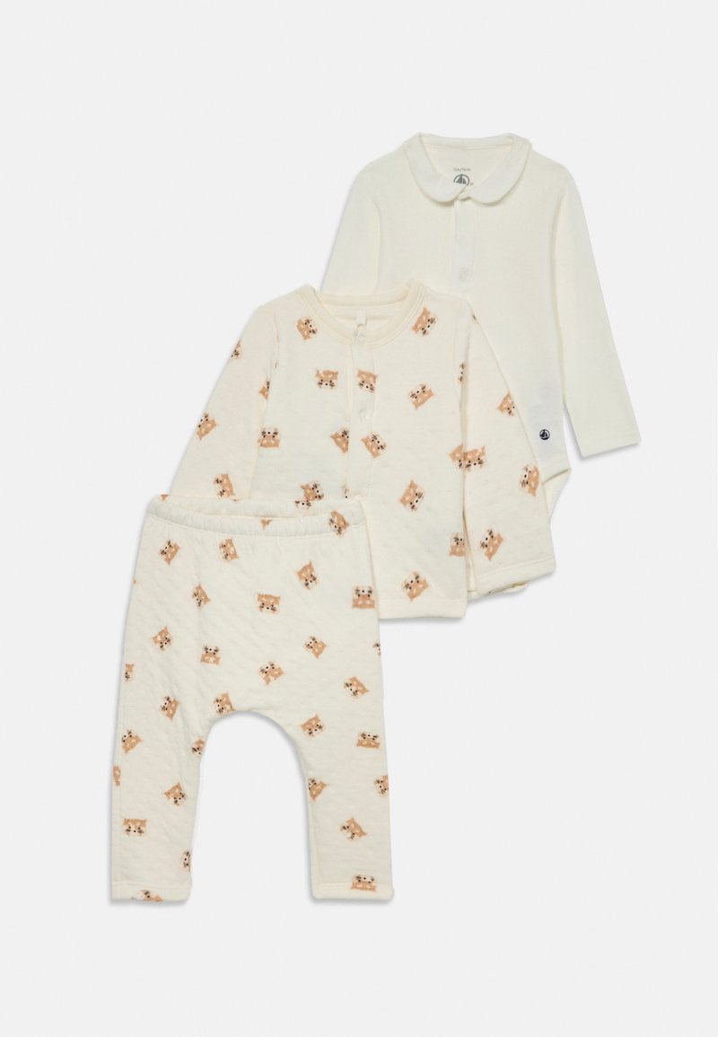 Set med tre babykläder i mjuk krämfärgad tyg: en enfärgad bodysuit, en mönstrad topp med djurtryck och matchande tryckta byxor.