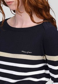 Pull rayé navy avec des rayures blanches et beige clair, col rond, et logo "Miseaugreen" brodé à l'avant. Texture tricot douce.