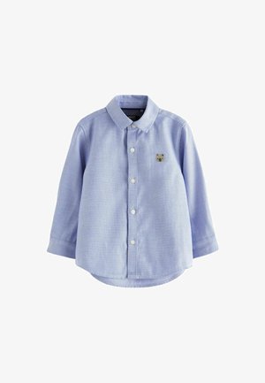 Cămașă cu mânecă lungă, de culoare albastru deschis, cu guler, confecționată dintr-un material țesut, având un broderie mică cu un urs aproape de piept și nasturi albi.