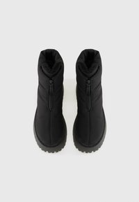 Botas negras de tobillo con un diseño acolchado, que cuentan con una cremallera lateral, suela de goma texturizada y forro suave para calidez y comodidad.
