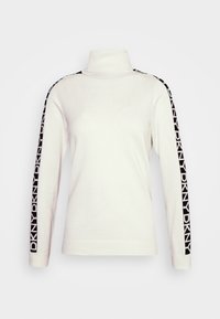 Vit polotröja med långa ärmar och svarta sidostråk med "DKNY"-tryck. Slät stickad struktur, klassisk passform.