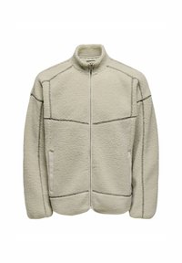 Giacca in pile beige chiaro con colletto alto, zip frontale e due tasche laterali. Presenta cuciture scure a contrasto lungo le cuciture.
