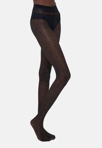 Schwarze gemusterte Strumpfhosen mit transparenter Textur und gepunktetem Design. Hoher Bund und glatte Verarbeitung, die die Beine betont.