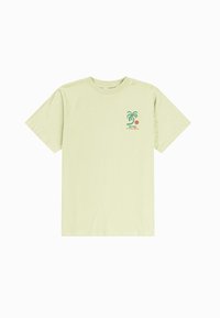 Camiseta de algodón verde claro con mangas cortas, que presenta un gráfico de una palmera y un círculo rojo en el lado izquierdo. Diseño clásico de cuello redondo.