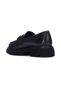 Mocasines de cuero negro con una suela de goma baja y gruesa. Presentan una correa única con un cierre de hebilla en tono plateado. Acabado liso con costuras mínimas.