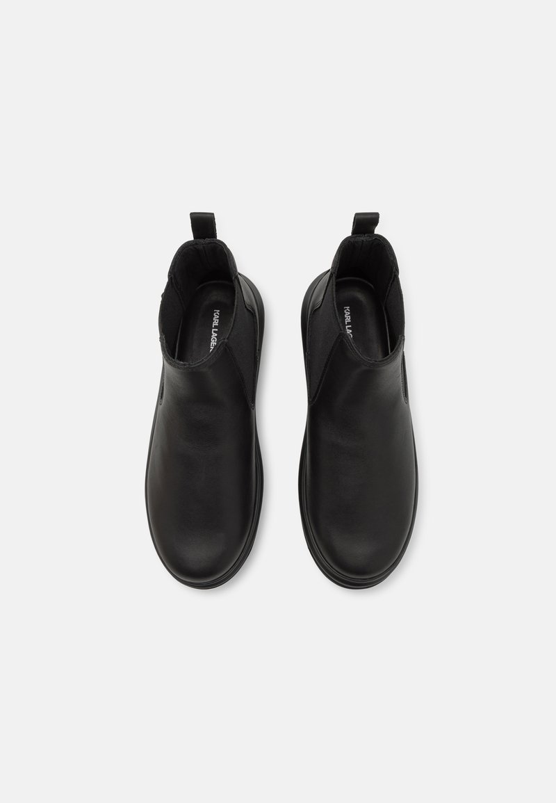 Schwarze Lederstiefeletten mit glatter Oberfläche, elastischen Seitenteilen und Ziehhilfen für einfaches Anziehen. Runde Zehenform und minimalistisches Design.