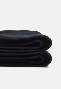 Zwarte fleece-deken, netje gevouwen, met een gladde textuur en consistente donkere kleur, die het zachte, warme materiaal benadrukt.