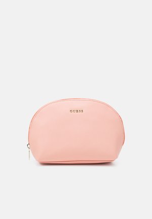 Bolso de cosméticos color durazno con forma redondeada, superficie texturizada, detalles en oro en el logo y cierre de cremallera. Diseño compacto y práctico.