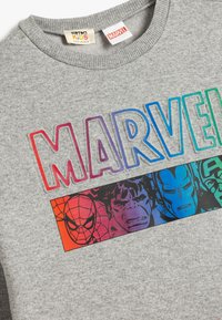 Sudadera gris con cuello redondo acanalado que presenta el texto "MARVEL" en varios colores e ilustraciones de superhéroes en un panel gráfico horizontal.