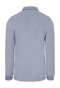 Lichtgrijze langwerpige polo shirt met een kraag, voorzien van een marineblauw accent langs de rand van de kraag. Zachte textuur, eenvoudig ontwerp.