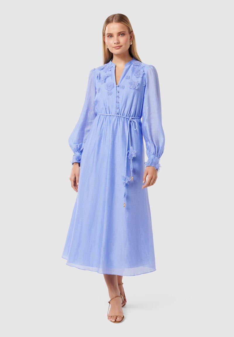Lyseblå maxi-kjole med lange ermer, v-hals, broderte blomsterdetaljer, knapper nedover fronten, innsnevret midje og ankel-lengde hem.
