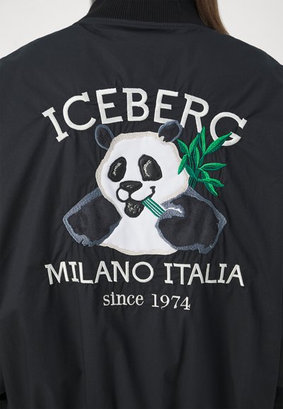 Giacca nera con design di panda ricamato, accento in bambù verde e testo bianco che legge "ICEBERG MILANO ITALIA dal 1974."