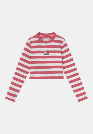 Chemise courte à manches longues avec des rayures horizontales rouges et blanches et un petit logo rectangulaire Tommy Hilfiger sur la poitrine.