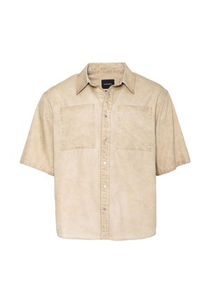 Camisa de manga corta en tejido beige con textura desgastada, que presenta dos bolsillos en el pecho y cierre frontal con botones de metal.