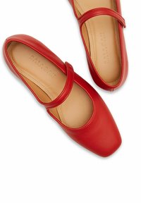 Bailarinas de cuero rojo con punta cuadrada, presentan una delgada correa en el empeine y un interior liso forrado con la marca "BALAGAN."