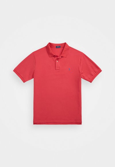 Rde majica polo iz bombaža z kratkimi rokavi, dvema gumboma na izrezu in majhnim modrim logotipom na levem prsnem delu. Gladka tekstura, klasičen kroj.