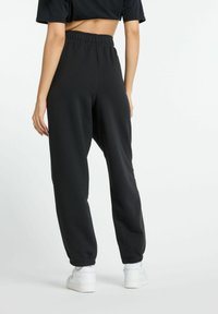 New Balance ESSENTIALS FRENCH JOGGER - Tracksuit bottoms - black