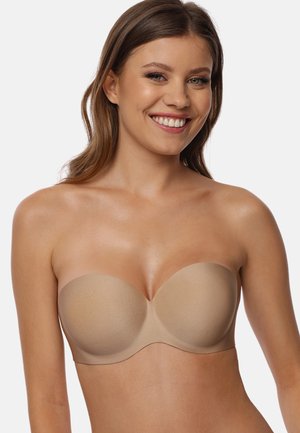 Beige strapless beha met gladde, gevormde cups en een naadloos ontwerp, met een zachte textuur en gebogen randen voor comfort.