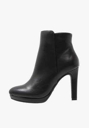 Bottine en cuir noir avec un bout pointu et un talon bloc haut, finition lisse, vue de côté.