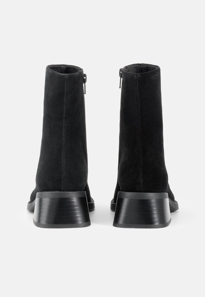 Bottines en suède noir avec un bout rond et un talon empilé noir. Équipées d'une fermeture éclair sur le côté pour un enfilage facile et d'une texture lisse.