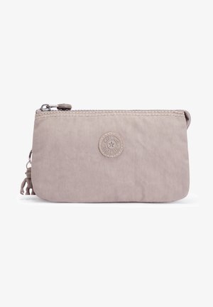 Hellbeige Reißverschlusstasche aus strapazierfähigem Material, mit einem runden Logo-Patch und einer kleinen dekorativen Figur am Reißverschlussanhänger.