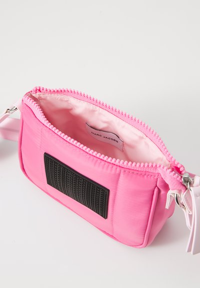 Liten rosa nylonhandväska med en texturerad svart lapp, blixtlåsuppdrag, och inre satinfoder, med en avtagbar rem.