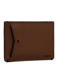 Porte-cartes en cuir marron avec des bords cousus, comportant une poche latérale et le logo "FOSSIL" embossé à l'avant. Texture lisse, design slim.