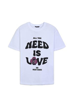 T-shirt en coton blanc avec un texte noir : "TOUT CE DONT VOUS AVEZ BESOIN, C'EST L'AMOUR" et "FLEURS FRAÎCHES", avec une illustration de fleur violette en dessous.