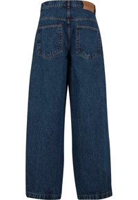 Ruimvallende donkerblauwe denim jeans met een gestructureerde afwerking, voorzien van twee achterzakken en een leren merklabel op de tailleband.