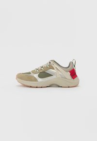 Sportschuhe mit olivgrünem Veloursleder- und Mesh-Obermaterial, beigen Akzenten, reflektierenden Details und einem roten Logotag an der Ferse. Gummisohle.