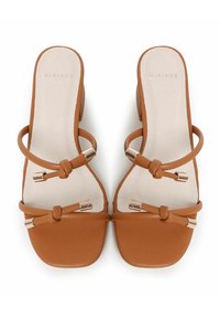Sandali con tacco in finta pelle marrone, con punta quadrata, cinturini sottili, dettagli in metallo dorato e una soletta liscia e strutturata.