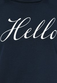 Maglietta blu navy con una texture morbida, caratterizzata dalla parola "Ciao" scritta in grandi lettere bianche corsive sulla parte frontale.
