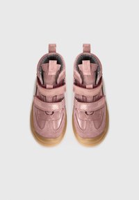 Rosa Kindersneaker mit doppeltem Klettverschluss und beige Gummisohlen, von oben auf einem weißen Hintergrund betrachtet.