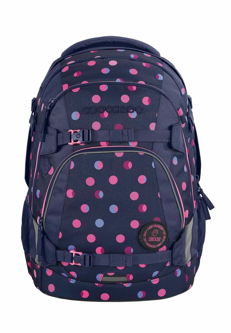 Navy blue backpack with pink and light blue polka dots, featuring adjustable straps, a logo patch, and multiple zippered compartments.