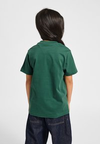 Grøn bomulds T-shirt med rund hals og korte ærmer, set bagfra, med en glat tekstur og ingen synlige grafik eller mønstre.