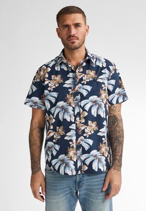 Kortaf shirt van marineblauwe katoen met een bloemenpatroon met grote bladeren en bloemen in crème, beige en oranje tinten. Met knoopsluiting aan de voorkant.
