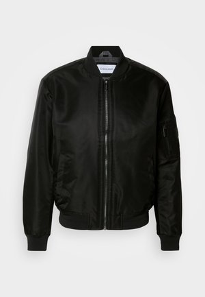 Giubbotto bomber nero realizzato in nylon lucido, dotato di zip frontale, polsini e orlo a coste, e una tasca con zip sulla manica sinistra.