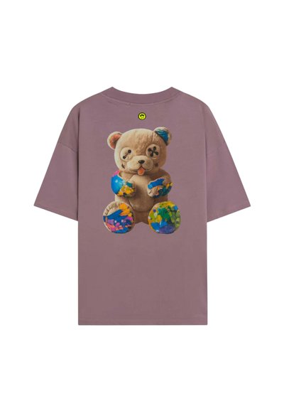 T-shirt in muted purple with a graphic of a teddy bear with button eyes and colorful paint splatters on its paws and feet.