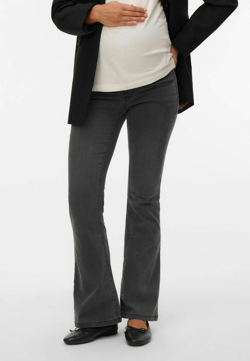 Hallid laiendatud teksad pehmest denimmaterjalist, keskmise kõrgusega vöökohaga; kombineeritud valge topi ja musta bleiseriga. Komplekti lõpetavad mustad madalad kingad.