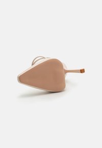 Chaussure à talon haut avec un bout pointu, dessus beige lisse, fine bride et semelle en caoutchouc rose texturée. Présente un accent minimaliste à l'arrière du talon.
