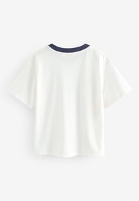 Fehér pamut póló tengerészkék kerek nyakkivágással, rövid ujjakkal és laza szabással. Simább textúra, egyszerű design, nincs látható minta vagy grafika.