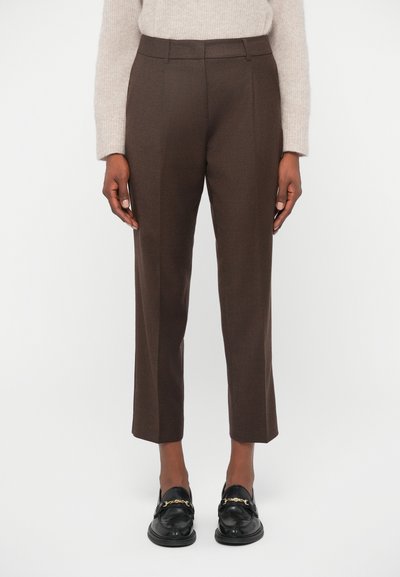 Pantaloni marroni su misura con una vestibilità dritta, caratterizzati da una texture liscia e pieghe sottili, abbinati a mocassini neri con accenti dorati.