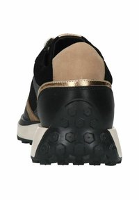 Zwarte, tan en gouden sneaker met een gevoerde hak, een gestructureerde rubberen outsole en een mix van suède en leren materialen. Hexagonaal profielpatroon.