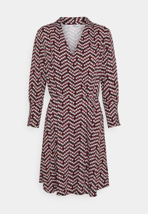 Sukienka z długim rękawem i dekoltem w kształcie litery V, z czerwono-biało-czarnym kwiatowym wzorem w zygzak na jasnym tle, taliowana, o długości do kolan.